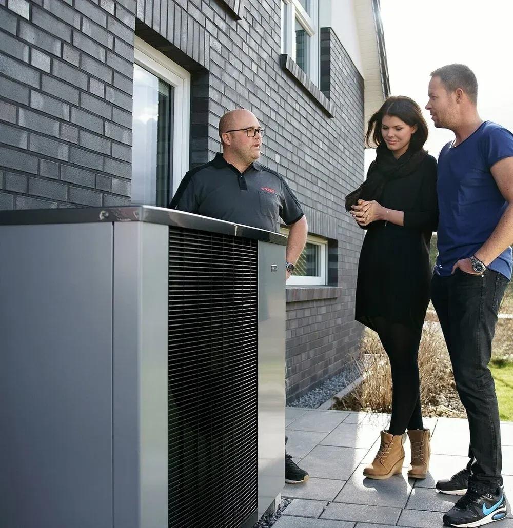 Luftwärmepumpe vor einem Einfamilienhaus mit Klinkerfassade